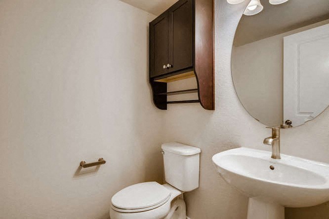 a bathroom with a toilet and a sink and a mirror