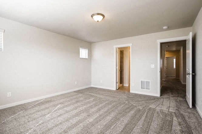 an empty living room with a door to a hallway