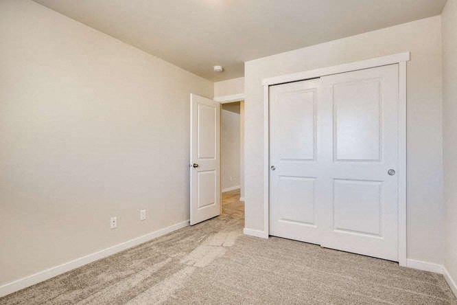 an empty bedroom with a closet and a door