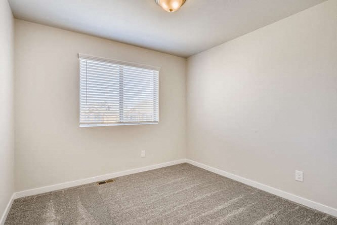 an empty room with a window and a carpet