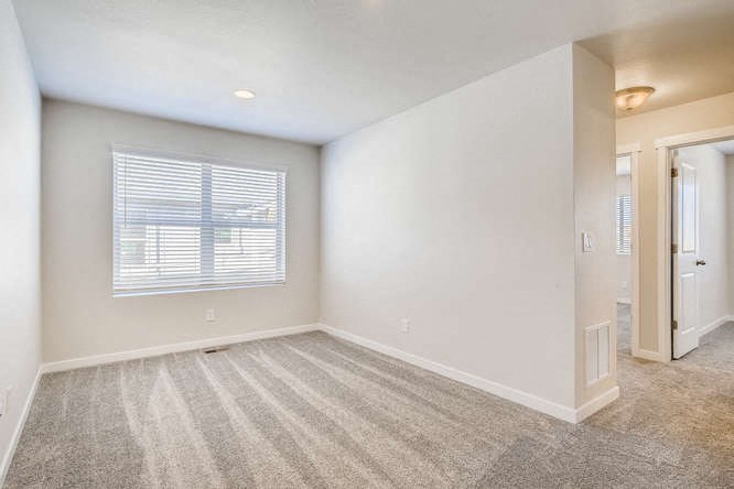 an empty living room with a window and a door