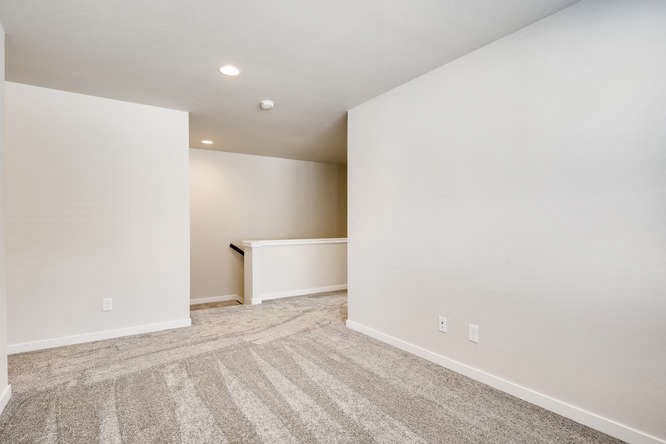 an empty living room with white walls and carpet