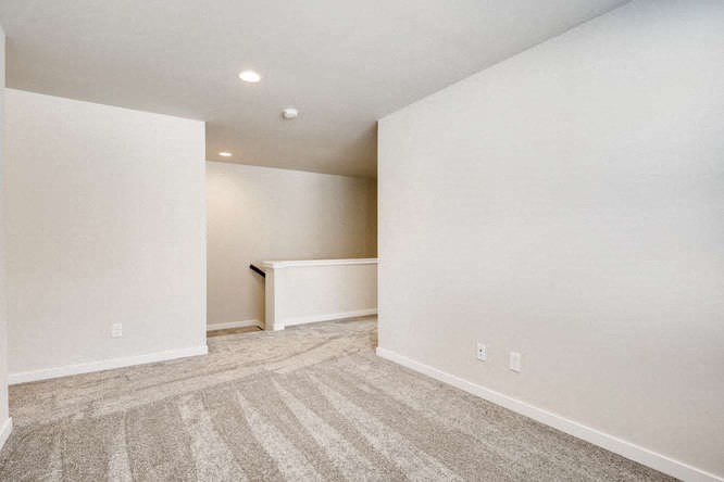 an empty living room with white walls and carpet