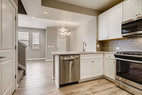 a kitchen with white cabinets and stainless steel appliances