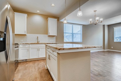 a kitchen with white cabinets and a counter top