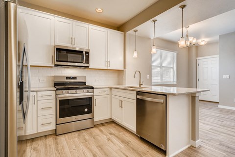 a kitchen with white cabinets and stainless steel appliances