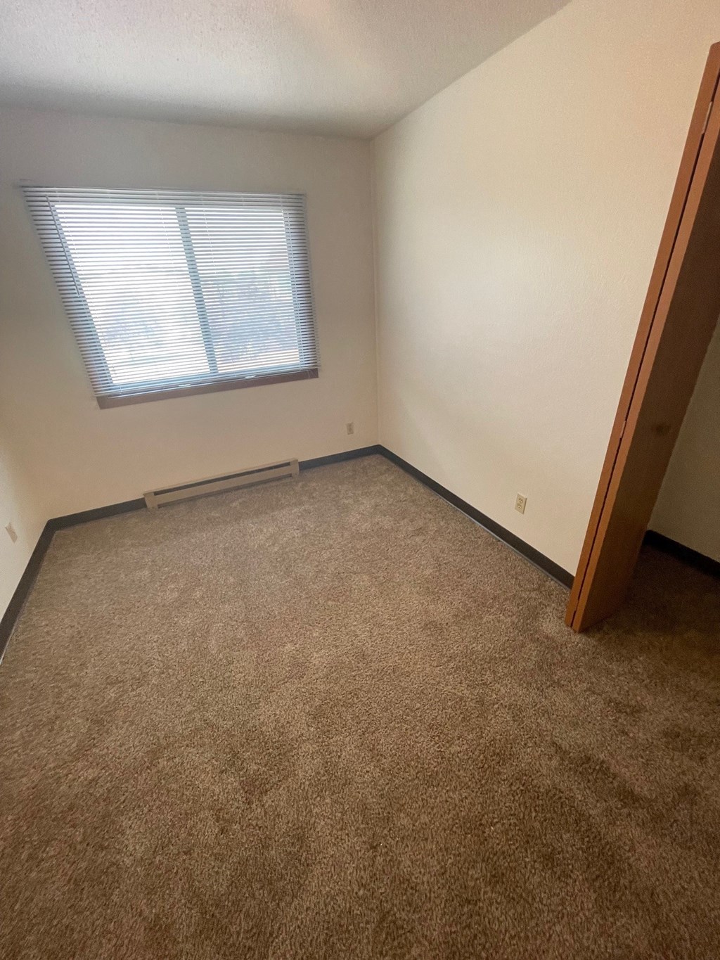 an empty room with carpet and a window