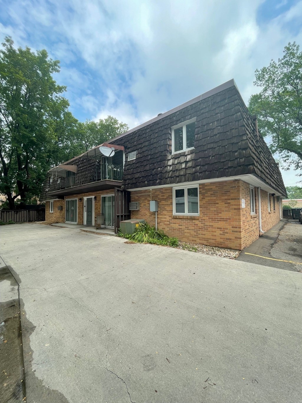 the front of a brick house with a parking lot