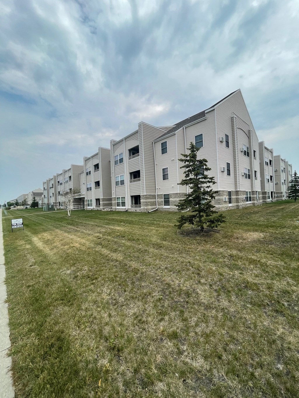 a view of an apartment building with a grass field