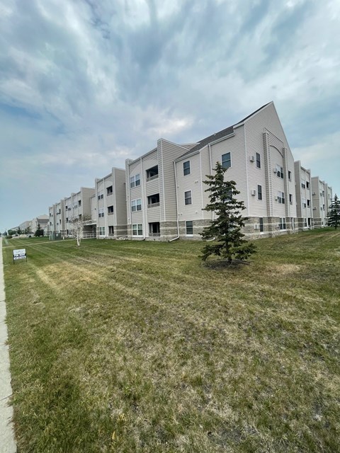 a view of an apartment building with a grass field