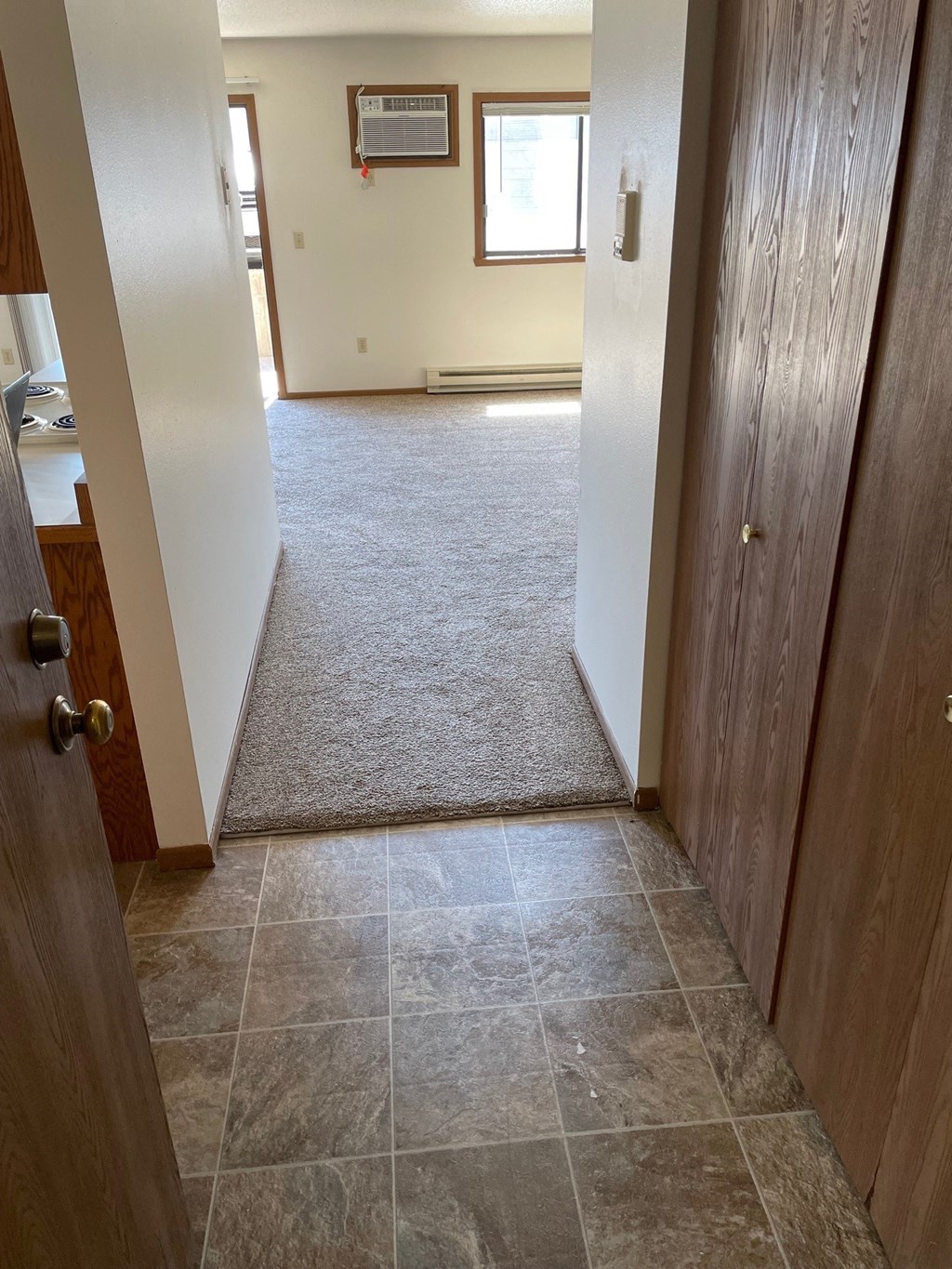 an empty hallway with two doors and a carpeted floor