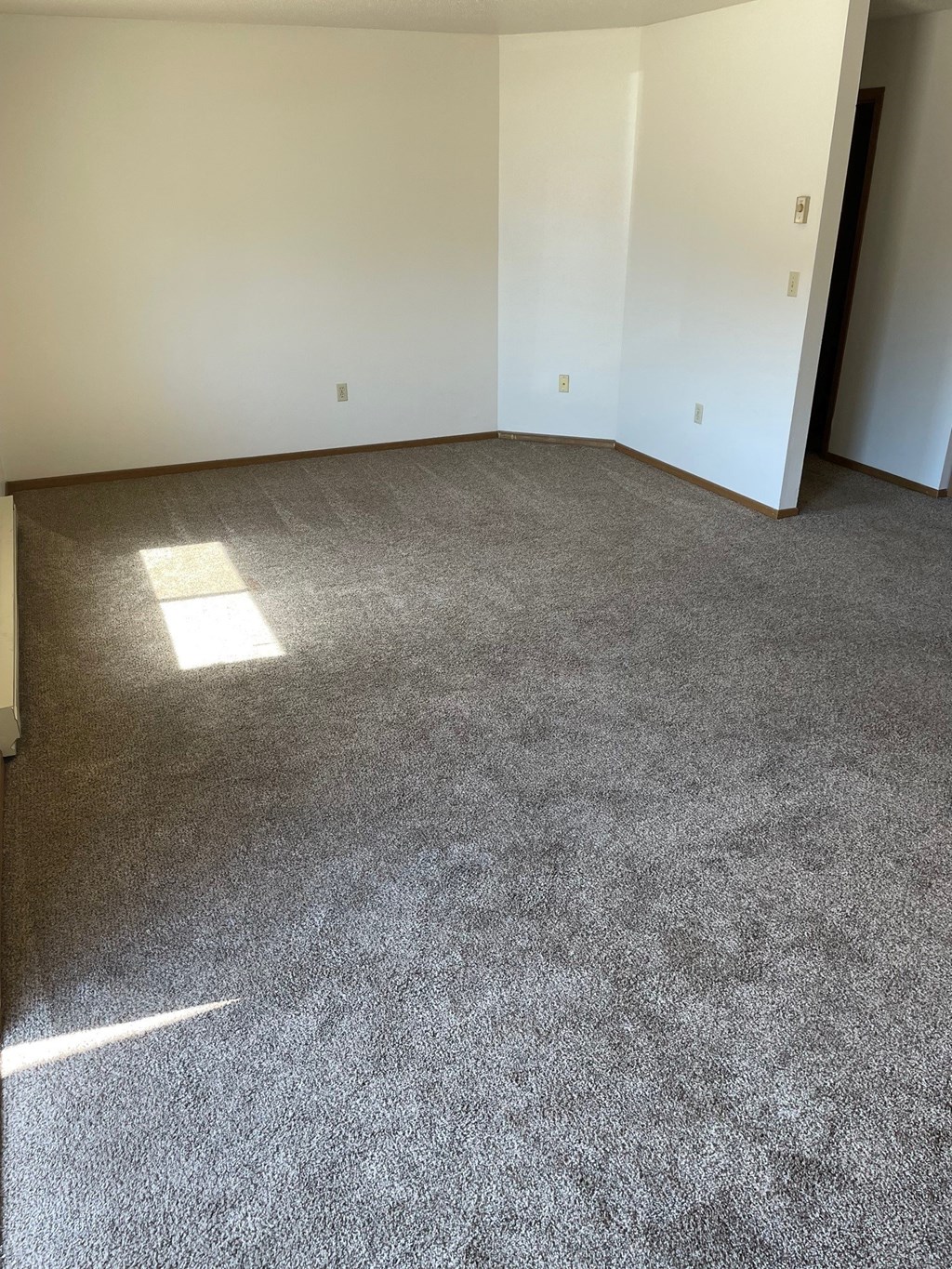 a room with a carpeted floor and white walls