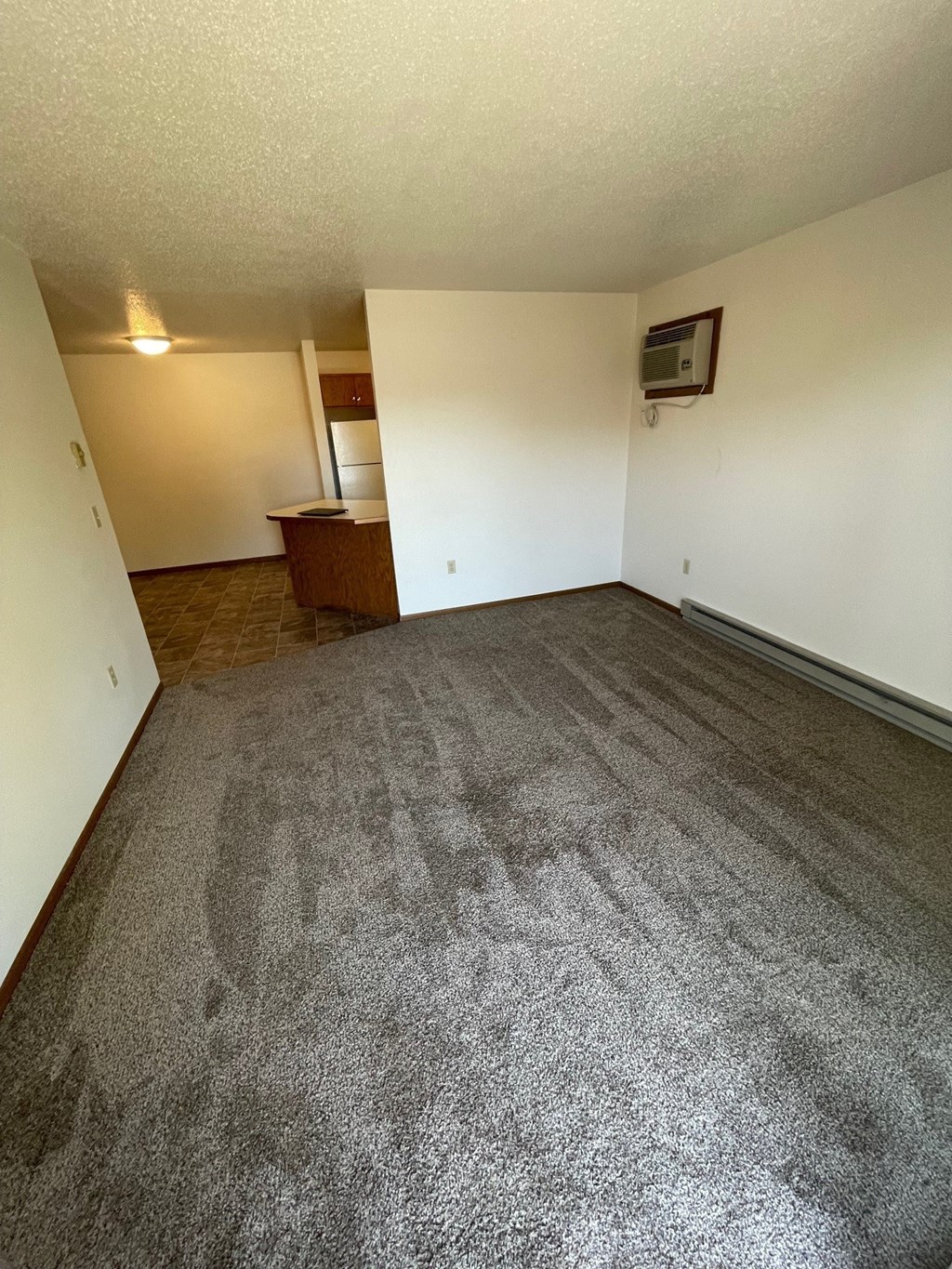 an empty living room with carpet and white walls