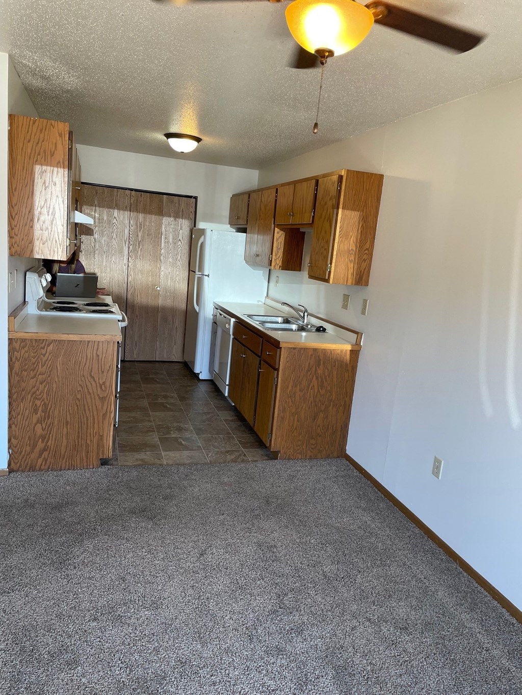 a kitchen with wooden cabinets and a sink and a refrigerator