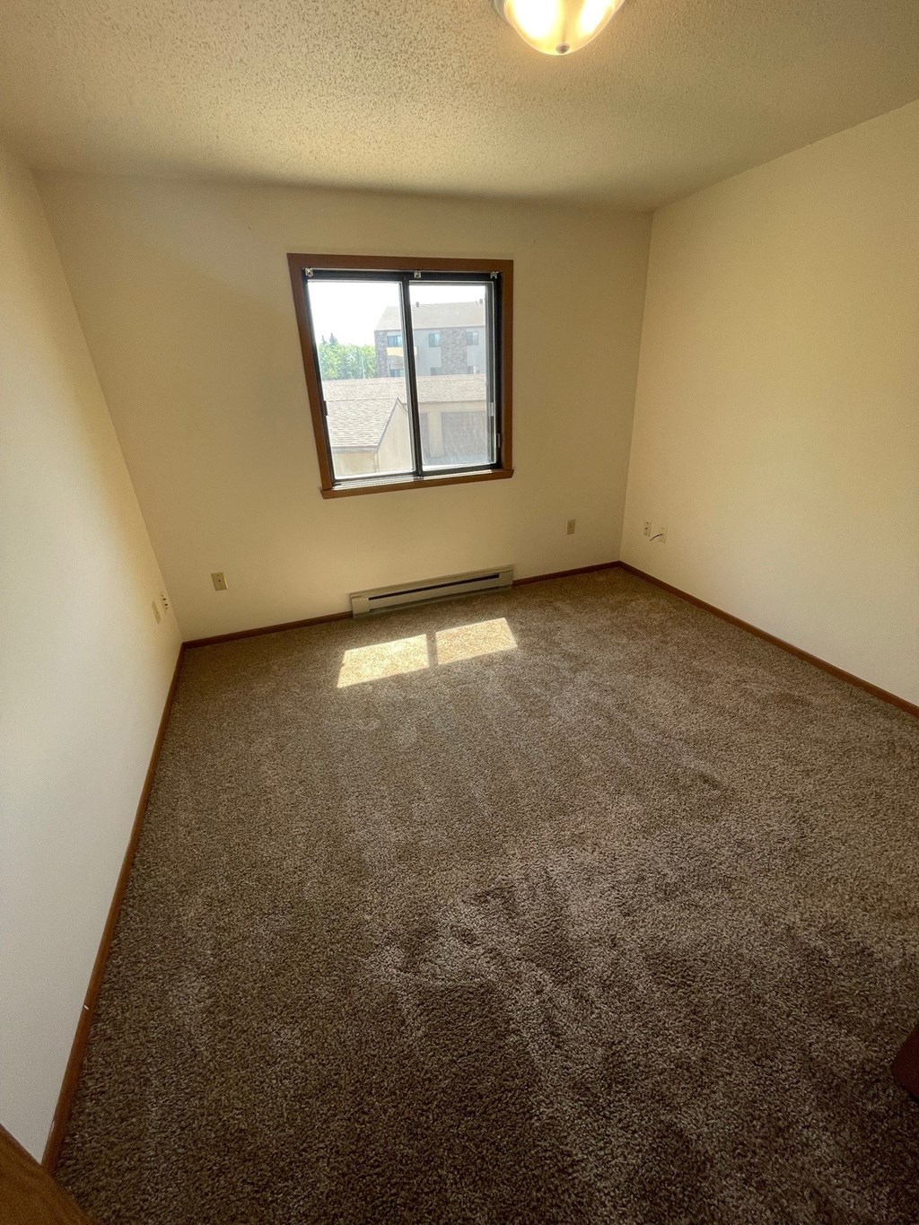 an empty room with carpet and a window