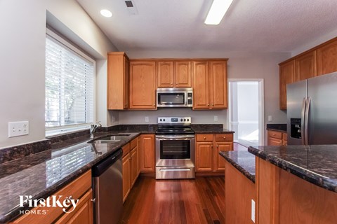 A kitchen with wooden cabinets and a stainless steel refrigerator.