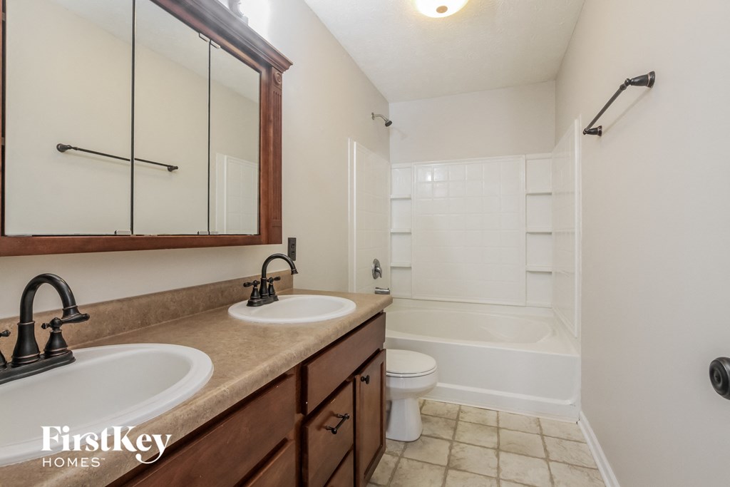 a bathroom with two sinks and a shower and a toilet
