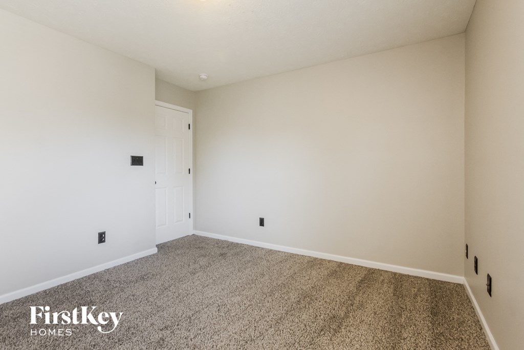 a empty room with carpet and white walls