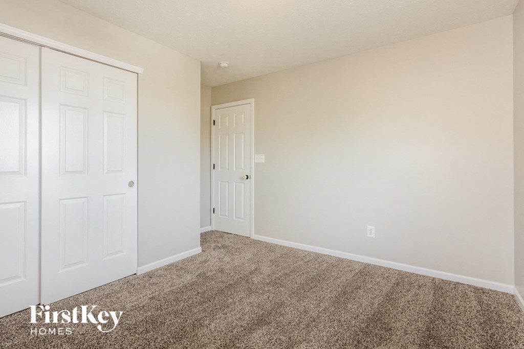 a bedroom with two closets and a carpeted floor