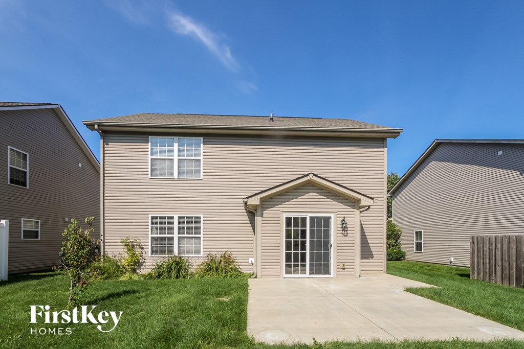 a beige house with a sidewalk in front of it