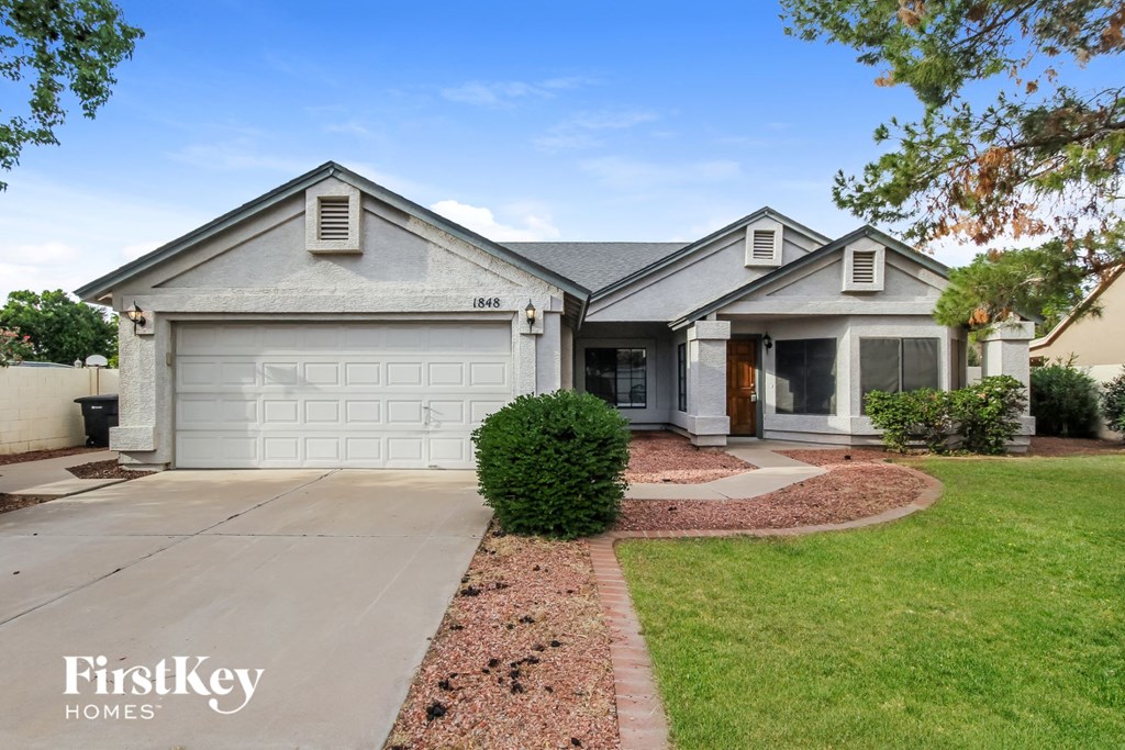 a white house with a driveway and a garage door