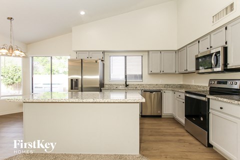 a kitchen with white cabinets and stainless steel appliances