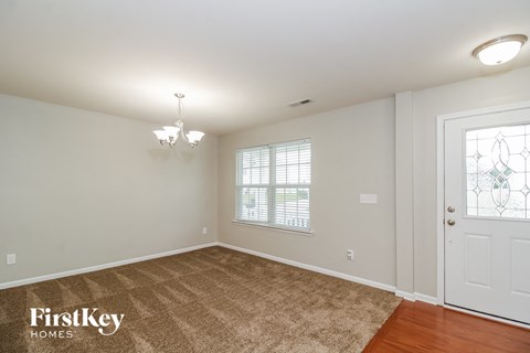 a living room with a rug and a white door