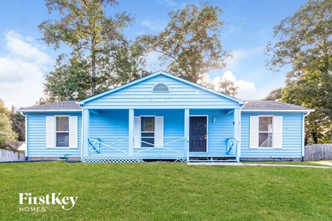 A blue house with a white picket fence in front.