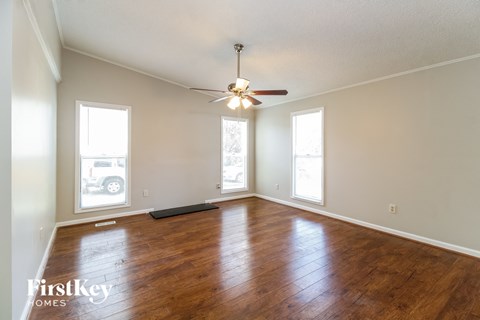 A room with wooden floors and a ceiling fan.