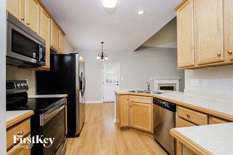 A kitchen with wooden cabinets and black appliances.