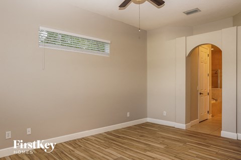 a living room with wooden floors and a ceiling fan