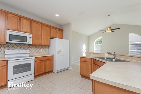 A kitchen with wooden cabinets and a white refrigerator.
