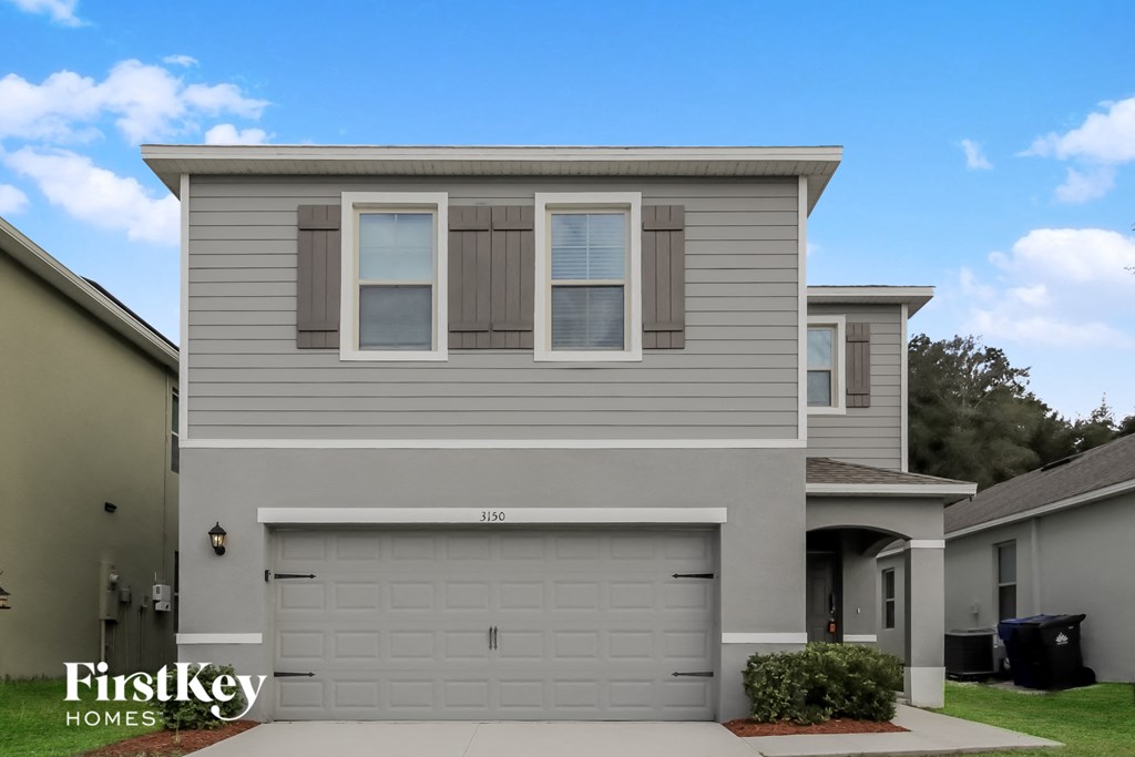 A two-story house with a garage is for sale.
