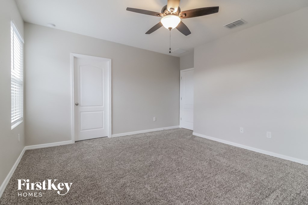 A room with a ceiling fan and two doors.