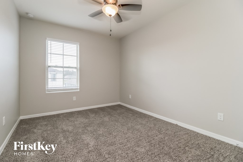 A room with a ceiling fan and a window.