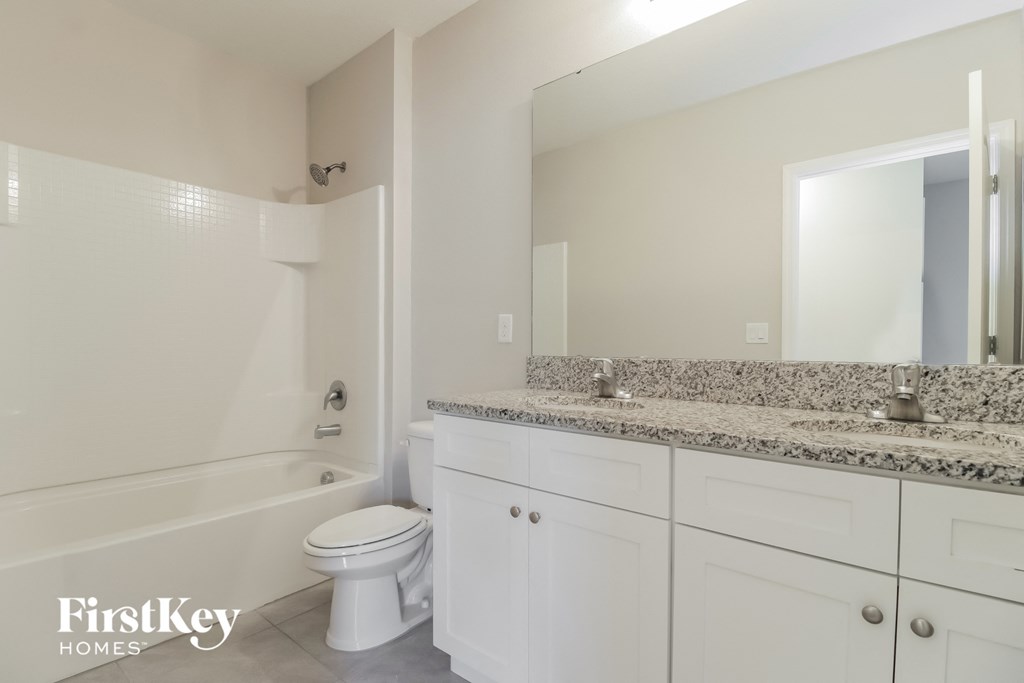 A bathroom with a white toilet, a sink, and a bathtub.