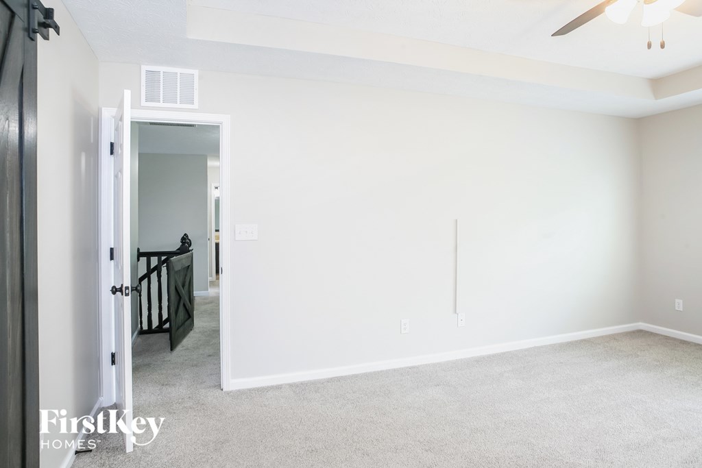 a living room with a white wall and a door to a hallway