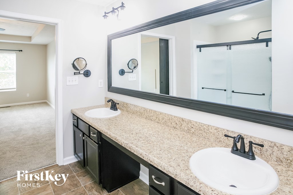 a bathroom with two sinks and a large mirror