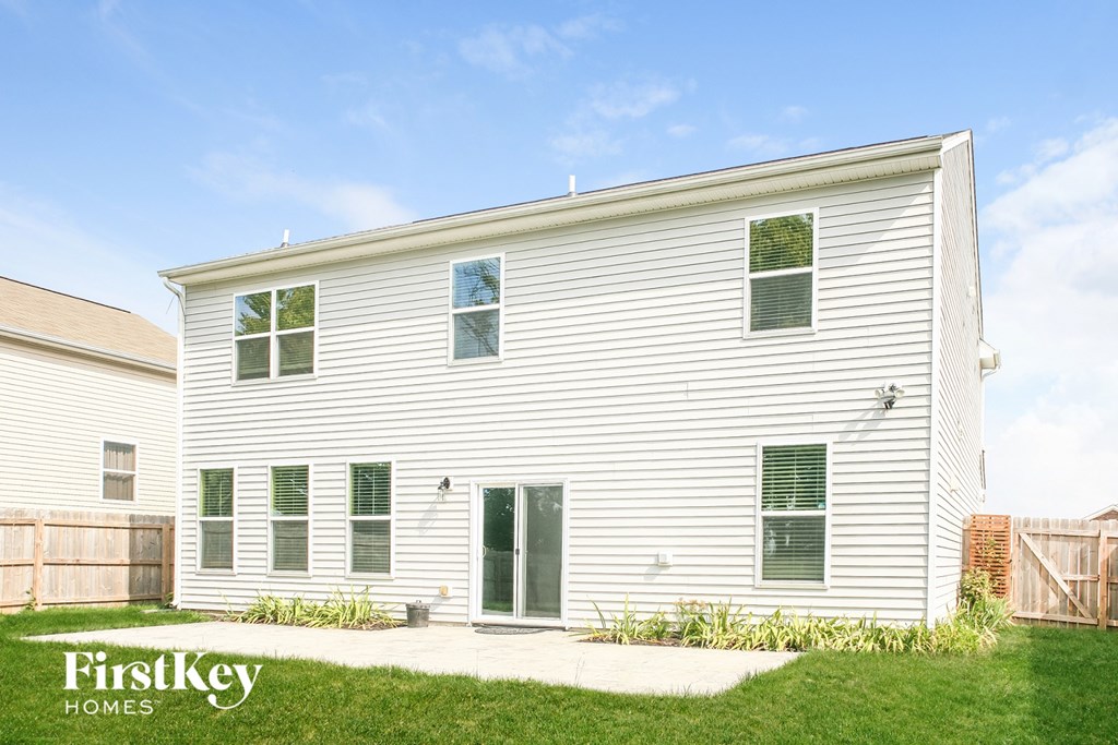 a white house with green shutters on a sunny day