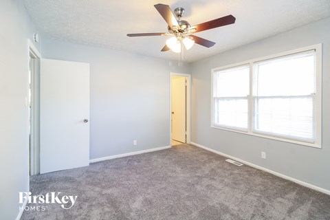 a living room with a ceiling fan and a large window