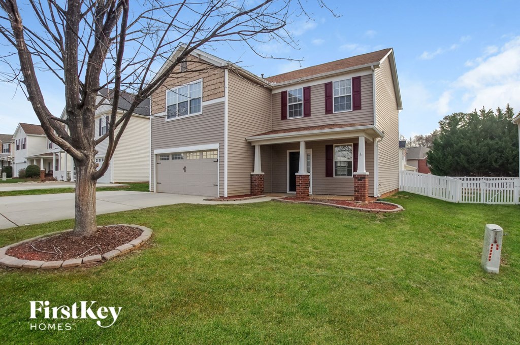 a home with a lawn and a tree in the front