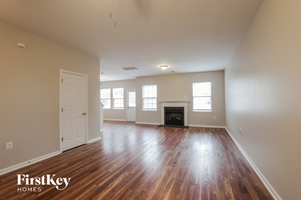 an empty living room with wood floors and a fireplace