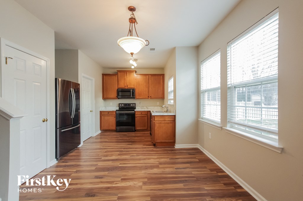an empty kitchen with wood flooring and a large window