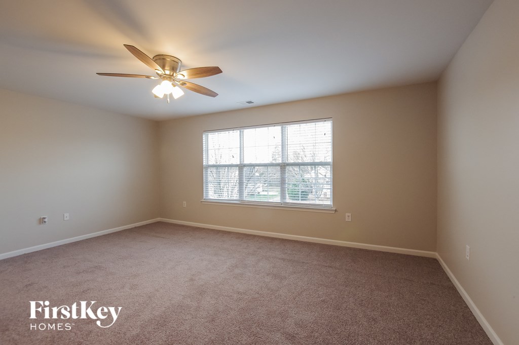 a bedroom with a ceiling fan and a window