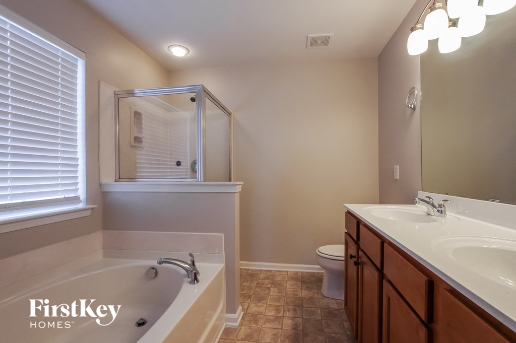 a bathroom with a tub and a sink and a toilet