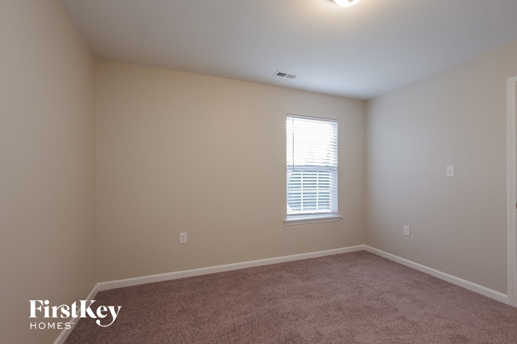 a bedroom with beige walls and a window