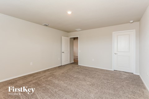 a spacious living room with carpet and white doors