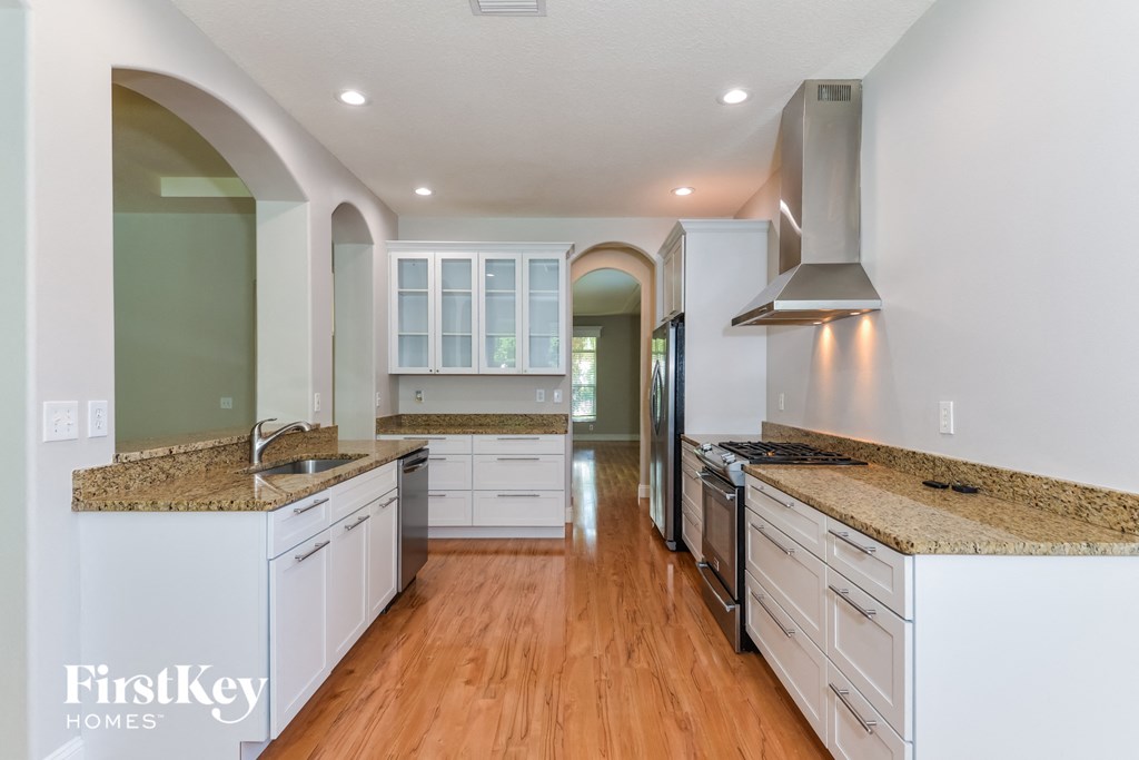 A kitchen with a granite countertop and white cabinets.