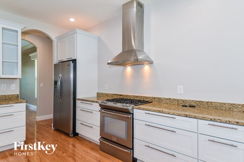 A kitchen with a stainless steel refrigerator and a stainless steel range hood.