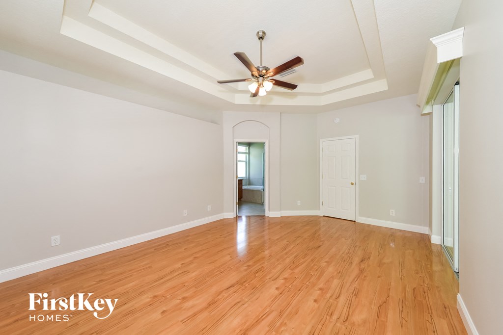 A room with wooden floors and a ceiling fan.